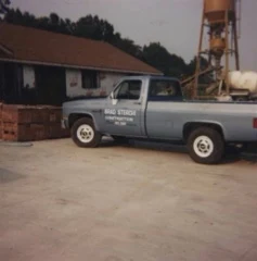Vintage blue Brad Sterchi Construction pickup truck photographed at a construction site.