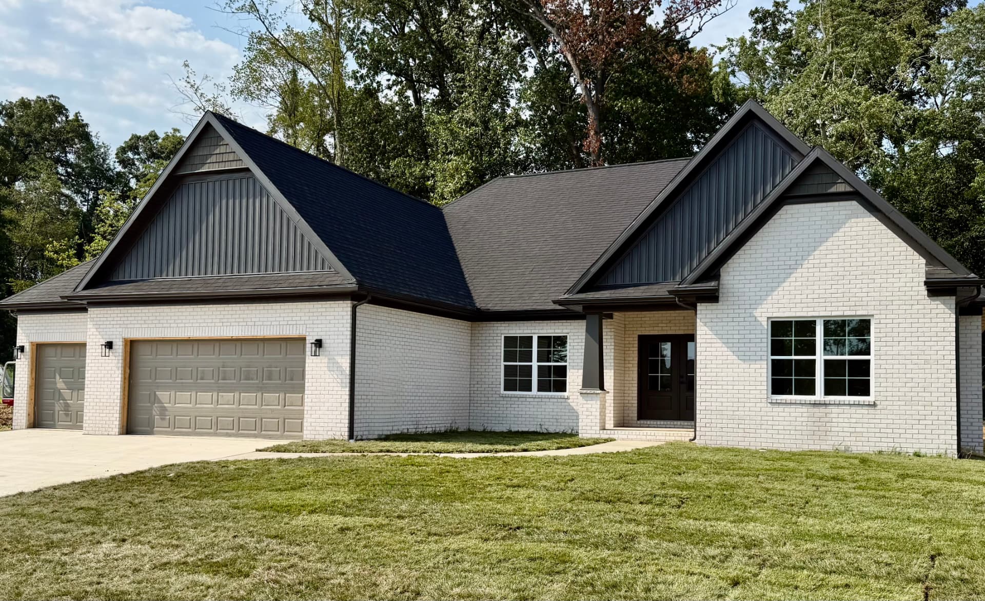 New Sterchi Homes residence with white brick exterior and black gabled roof in Evansville, Indiana
